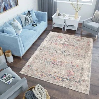 A living room scene with a blue sofa, a rug, and accent chairs.