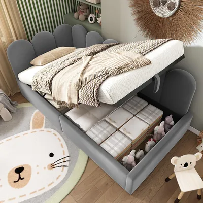 A child's bedroom with a grey velvet bed with storage, blankets, and stuffed animals.