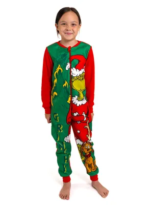 A young girl stands facing forward, wearing a Grinch-themed jumpsuit.