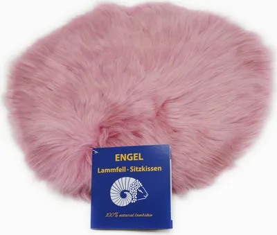 A pink sheepskin seat cushion with a blue product tag in front of it.