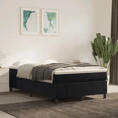 A bedroom scene with a bed, artwork, and a plant.