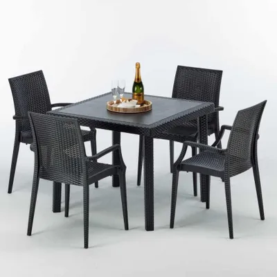 A black square table with four black chairs, set up for an outdoor dining scene.