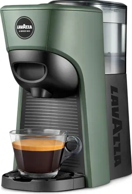 A green Lavazza coffee machine with a cup of espresso in front of it.