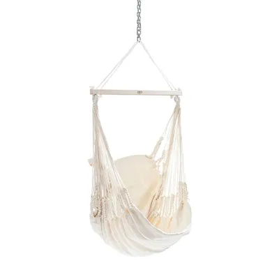 A white hammock chair hanging from a chain.