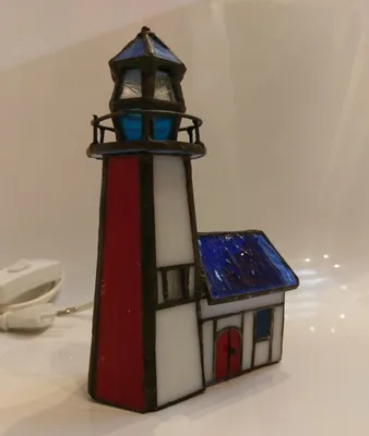 Tiffany-Leuchtturm mit roten und weißen Farben, einem blauen Dach und blauen Akzenten.