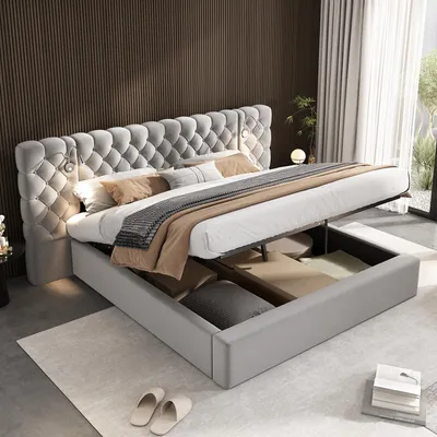 A luxurious grey upholstered bed with a tufted headboard and integrated storage is shown in a bedroom setting.