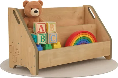 A wooden toy box filled with children's toys, including a teddy bear, alphabet blocks, and a rainbow stacker.