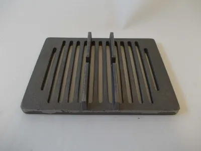 A cast iron grate for a stove or fireplace, shown from a slightly elevated angle on a plain background.