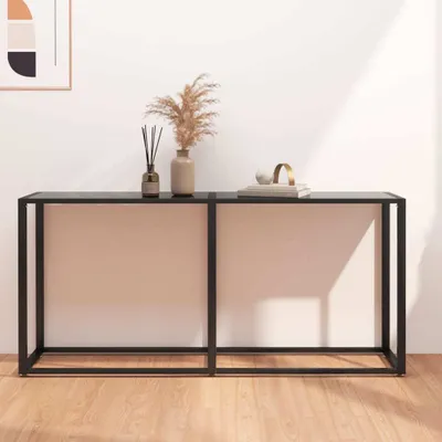 A console table with decorative items on top, placed against a white wall with natural light casting shadows.