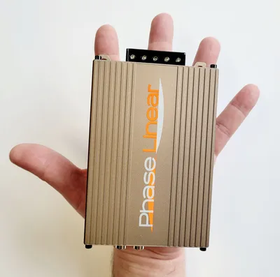 A hand holding a small electronic device.
