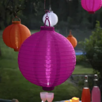 Several paper lanterns are hanging outdoors, with a table set for drinks in the foreground.