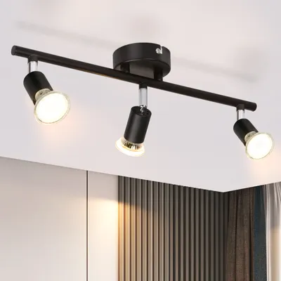 A black three-light track light fixture mounted on a white ceiling.
