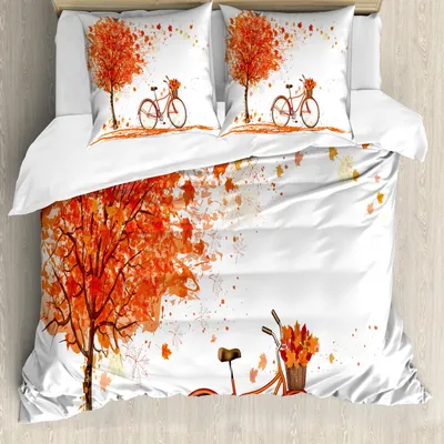 A duvet cover set with an autumn-themed print is laid out on a bed.