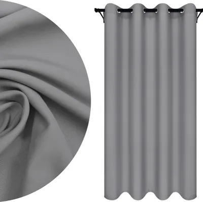 A close-up of fabric texture and a gray curtain hanging on a rod.