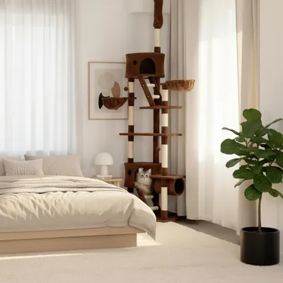 A cat tree is placed in a bedroom next to a bed, with a cat on the cat tree.