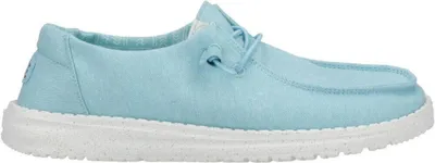 A side view of a single light blue canvas shoe with a white sole.