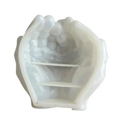 A white silicone mold in the shape of two cupped hands with shelves inside, shown against a white background.