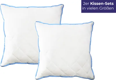 Two white pillows with blue trim are shown against a white background.