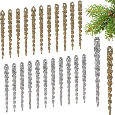 A collection of glittery icicle ornaments in silver and gold colors, arranged in rows and on the right side, with a hint of a green pine branch in the upper right corner.
