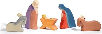 A nativity scene set with wooden figures of Mary, Joseph, baby Jesus, a donkey, and a cow.