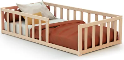 A wooden baby bed with railings and bedding.