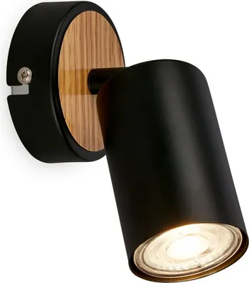 A black wall lamp with a wooden accent, mounted on a white background.