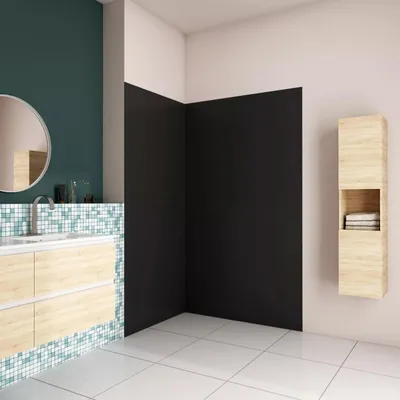 A modern bathroom with a vanity, sink, mirror, and a shower wall.