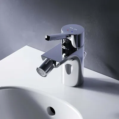 A chrome bidet faucet is shown on a white countertop next to a sink.