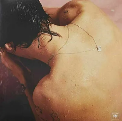 Close-up of a person's back and neck, with water droplets on the skin.