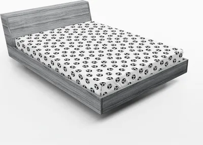 A fitted sheet with a repeating soccer ball pattern is shown on a bed frame.