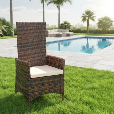 A brown rattan chair with a beige cushion is placed on a green lawn next to a swimming pool.