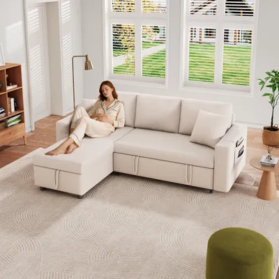 A woman is relaxing on a beige sectional sofa in a well-lit living room with large windows.