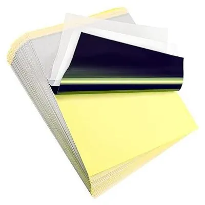 A stack of tattoo transfer papers, with the top sheets partially peeled back to reveal the layers.