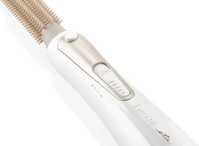 A close-up shot of a white hair styling tool with a beige brush attachment, set against a white background.