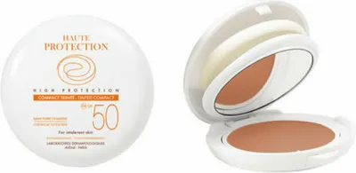 A compact sunscreen and its open case with a mirror and applicator.
