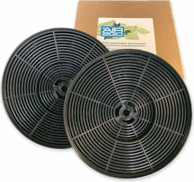 Two circular black carbon filters are shown with a cardboard box and a label in the background.