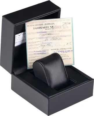 A black watch box with a vintage ticket inside.