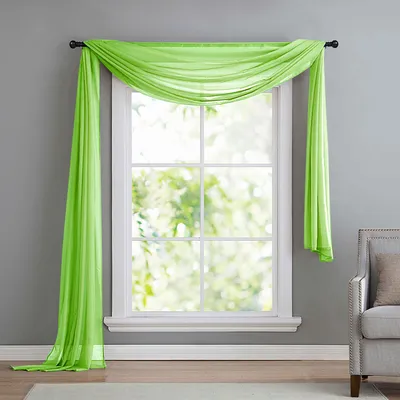 A sheer green scarf draped over a window.