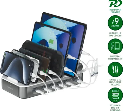 A multi-device charging station with several phones and tablets plugged in and charging.