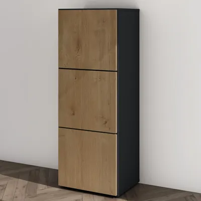 A tall, narrow shoe cabinet with three wooden-fronted drawers stands against a plain wall.