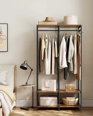A bedroom scene with a clothing rack and bedside table.