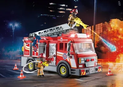 A toy fire truck with firefighters in action at night with flames in the background.