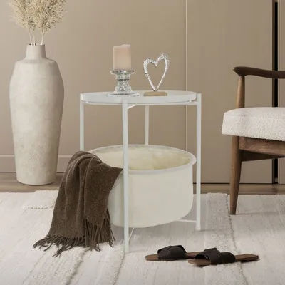 A cozy living room scene featuring a side table with a basket, a blanket, and decorative items.