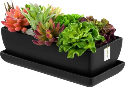 A black ceramic rectangular planter filled with various artificial succulents, placed on a matching black saucer.