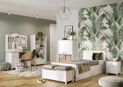A bedroom with a desk, bed, and storage units, decorated with a tropical leaf wallpaper.