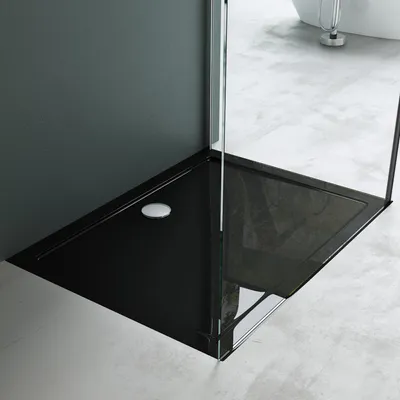 A modern black shower tray with a drain in a bathroom setting.