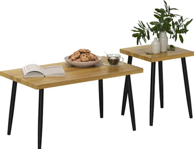 A set of two wooden coffee tables with black metal legs, one larger and one smaller, displayed against a white background. The larger table has a book, a bowl of cookies, and a cup of coffee on it. The smaller table has a vase with greenery and two smaller