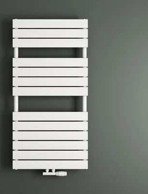 A white radiator is mounted on a gray wall.