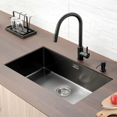 A modern kitchen sink with a black faucet and soap dispenser.