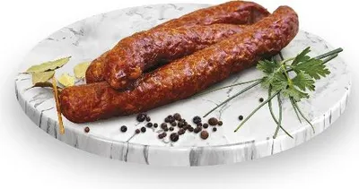 Three sausages are arranged on a marble-patterned platter with bay leaves, peppercorns, and parsley.